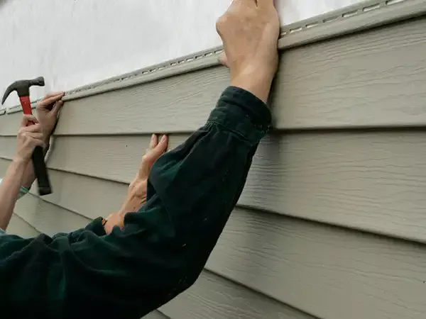 Worker installing new siding